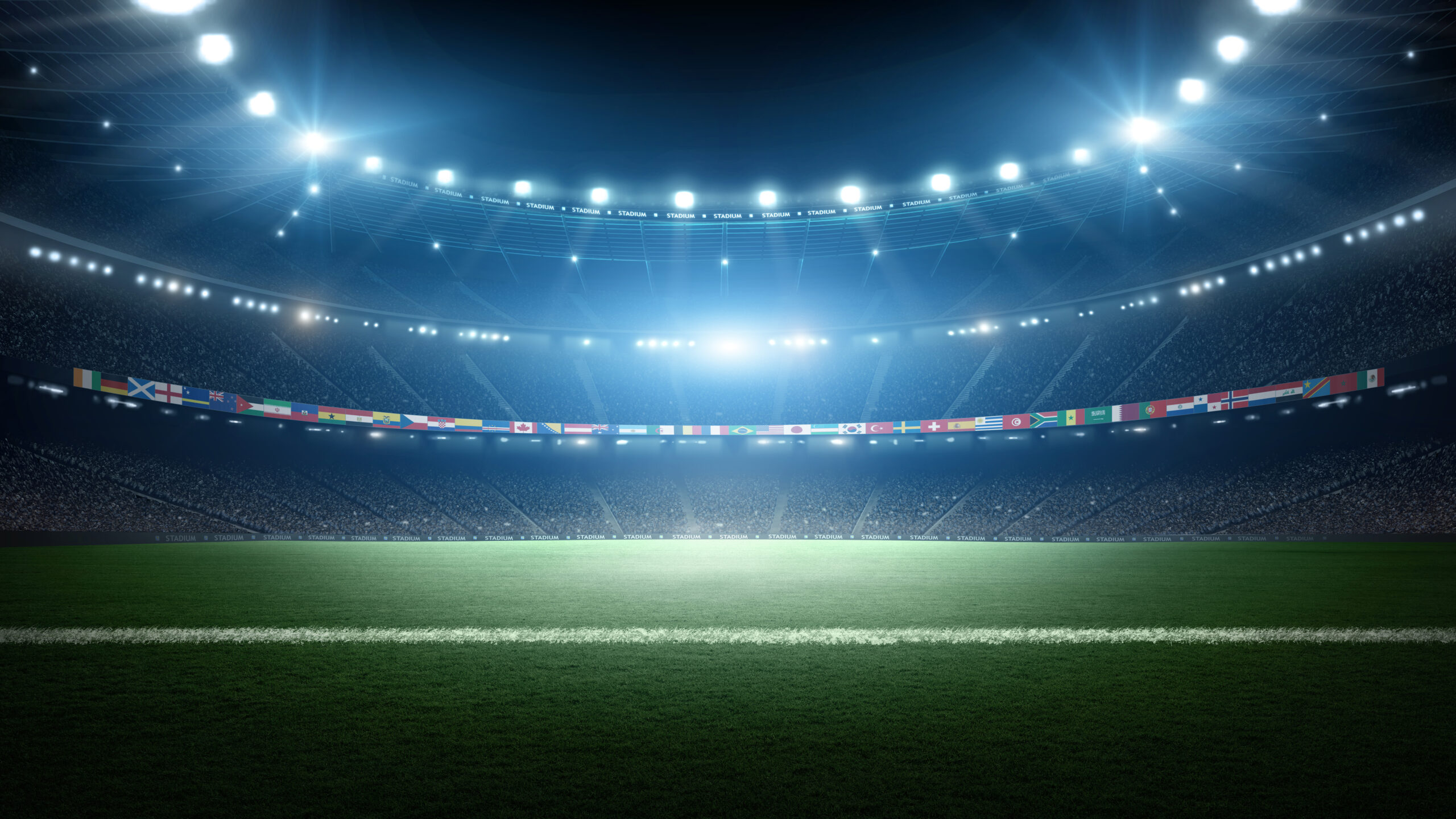 Illuminated soccer stadium with international flags at night