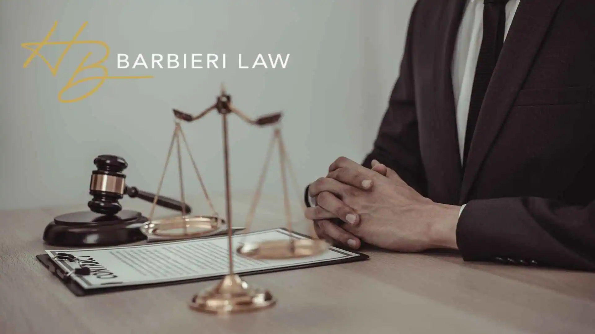 Attorney beside gavel, scales, and contract at Barbieri Law