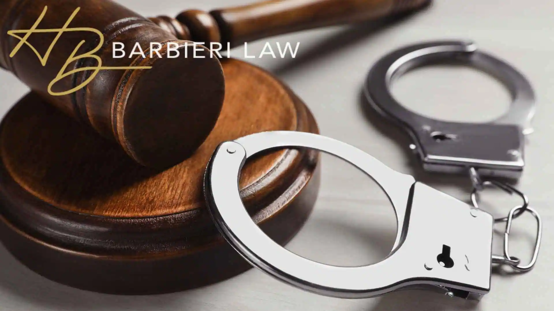 Judge’s gavel beside handcuffs with Barbieri Law logo