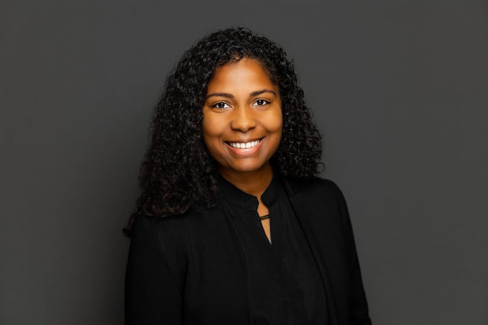 Smiling woman in black blouse against gray background