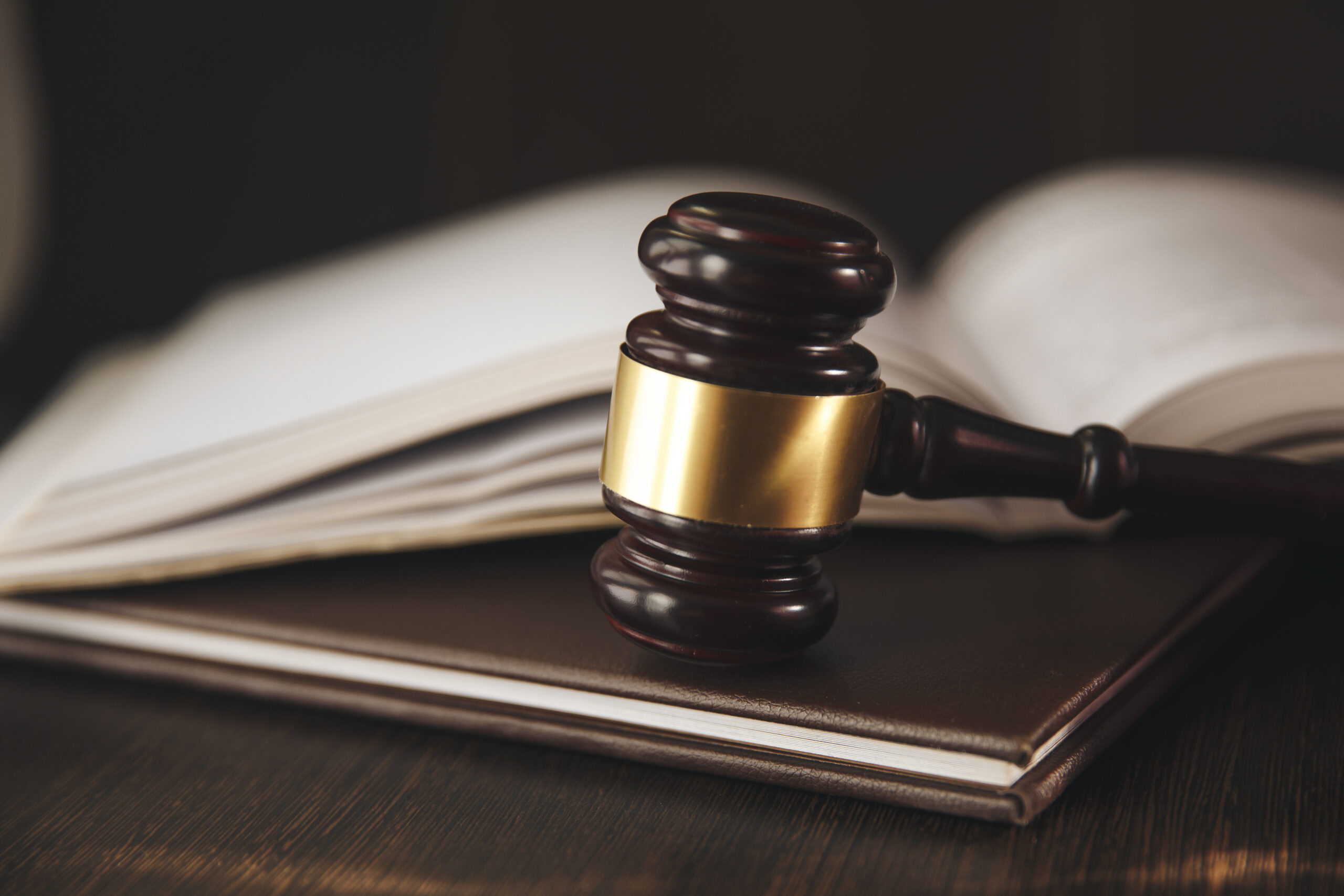 Wooden judge's gavel resting on stacked law books